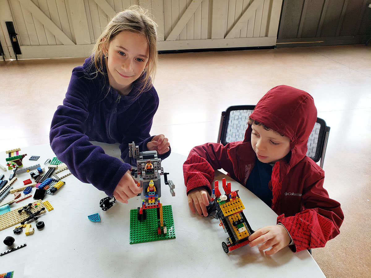 Girl and boy building and playing with LEGO models